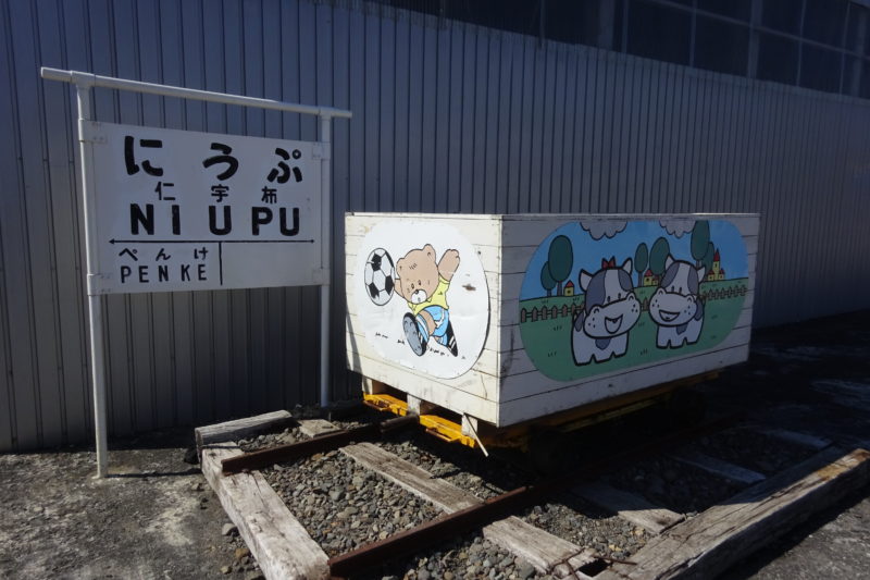 仁宇布駅(にうぷ)の駅名標と記念撮影用のトロッコ