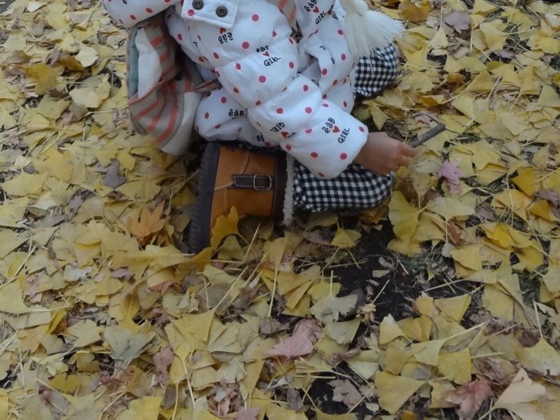 イチョウの落ち葉で遊ぶ子供